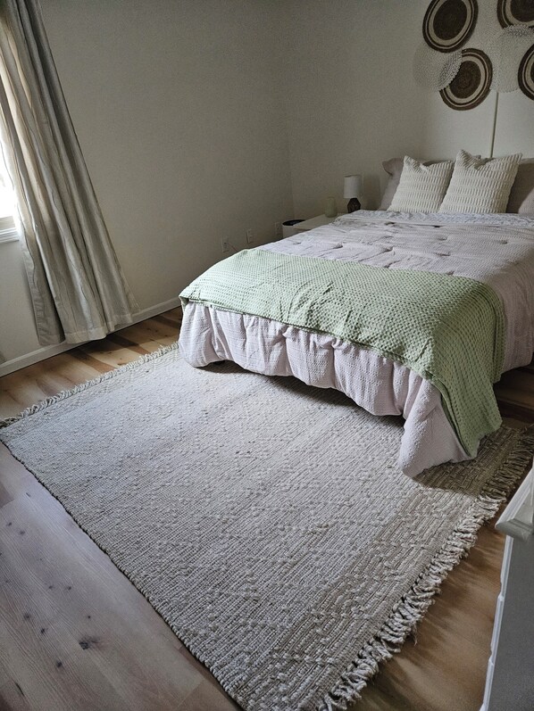 A bedroom with a bed, a large rug, and a wall with circular decorations.