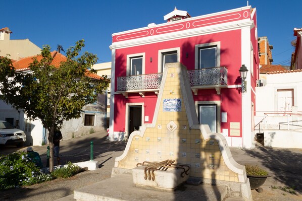 Un bâtiment rouge avec une façade recouverte de tuiles et un balcon.