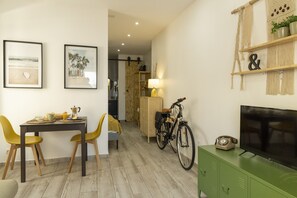Un comedor con una mesa, sillas y un televisor sobre un mueble.