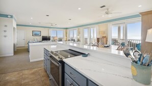 A spacious kitchen with a large island, built-in oven, and ample counter space.