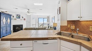 Eine Küche mit Geschirrspüler, doppelter Spüle und Deckenventilator.