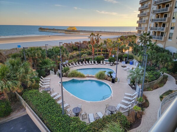 A resort with a pool area, lounge chairs, and a view of the beach and pier. - Direct oceanfront, 4 bedroom, 3 bath condo - Margate Tower 207 (Myrtle Beach)