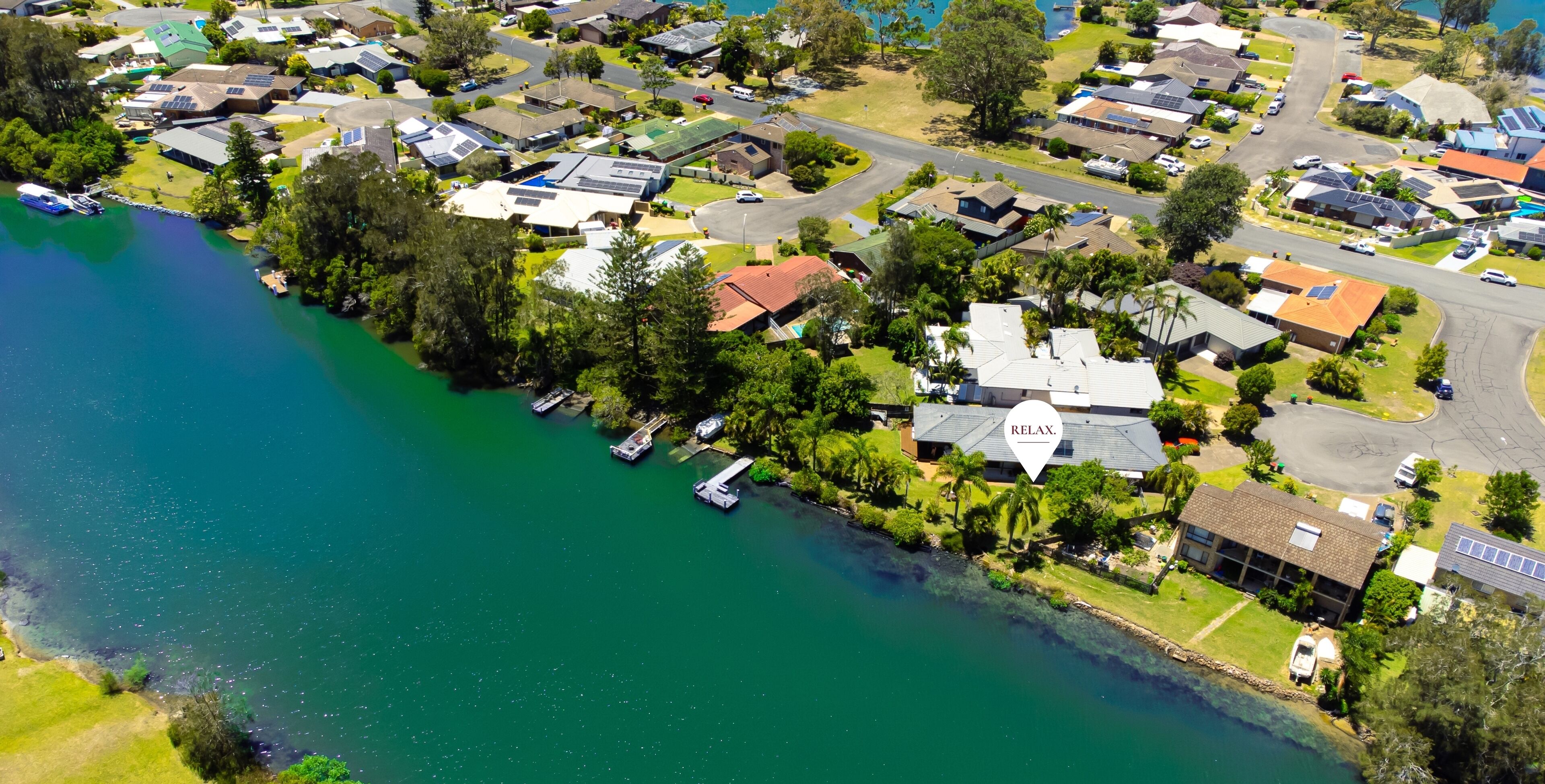 An aerial view of a residential area with houses, a marina, and a lake.