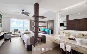 Relax in a spacious room with a large bed, seating area, and ocean views.
