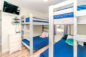 Habitación con literas, cómoda y televisor.