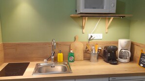 A compact kitchen with a microwave, coffee maker, and dishwasher.