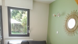 A modern living room with a grey sofa, a small round wooden table, and a woven rug.