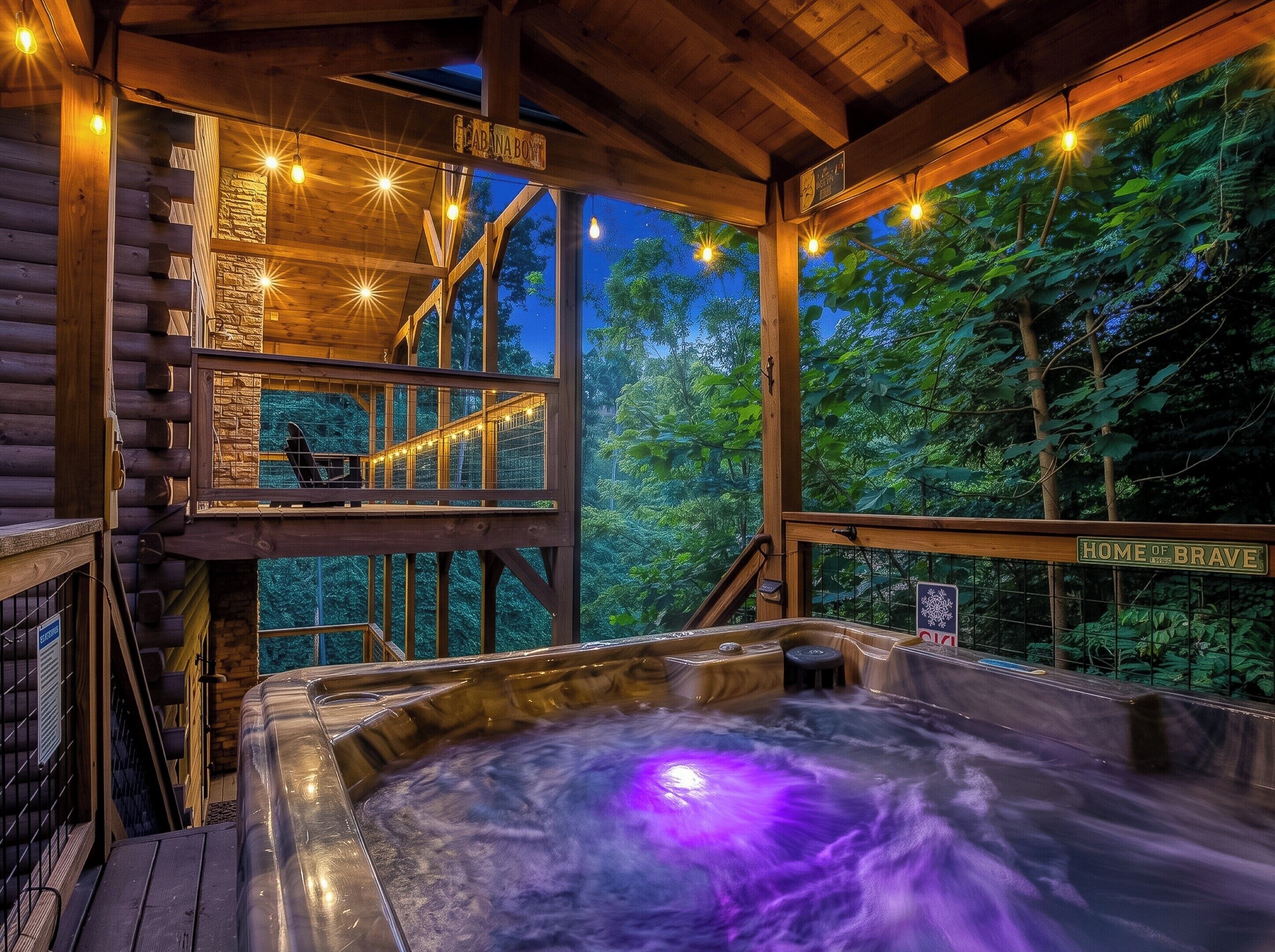 A wooden cabin with a hot tub, wooden deck, and a sign reading 'HOME OF BRAVE.'