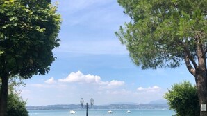 Een pad dat leidt naar uitzicht over een meer, met een bankje en een lantaarnpaal.