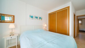 Una camera da letto con un letto, comodini, uno specchio e un armadio.