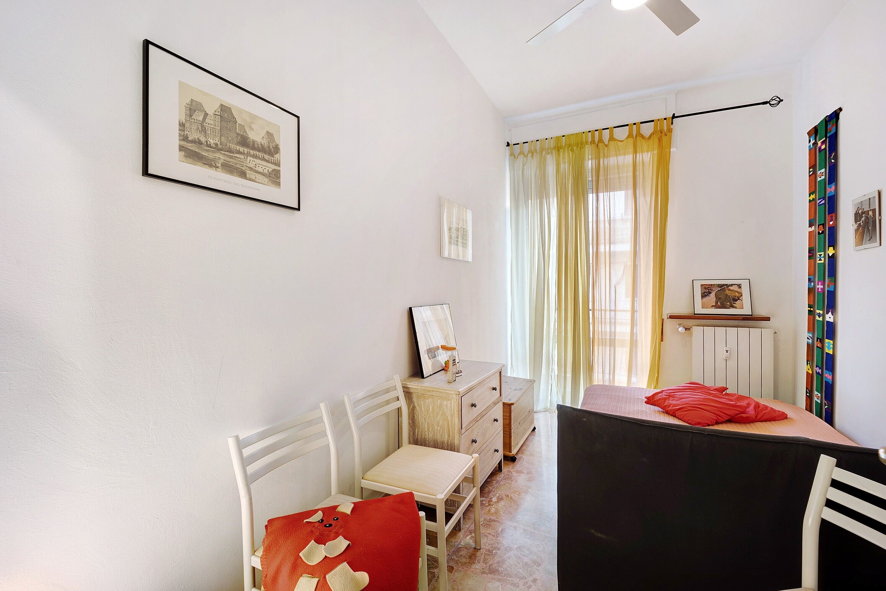 Une pièce comprenant un lit, un bureau, une chaise, une commode et un tableau encadré accroché au mur.