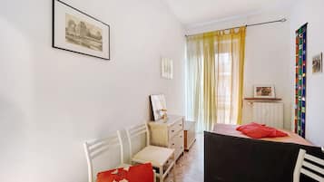 Une pièce comprenant un lit, un bureau, une chaise, une commode et un tableau encadré accroché au mur.