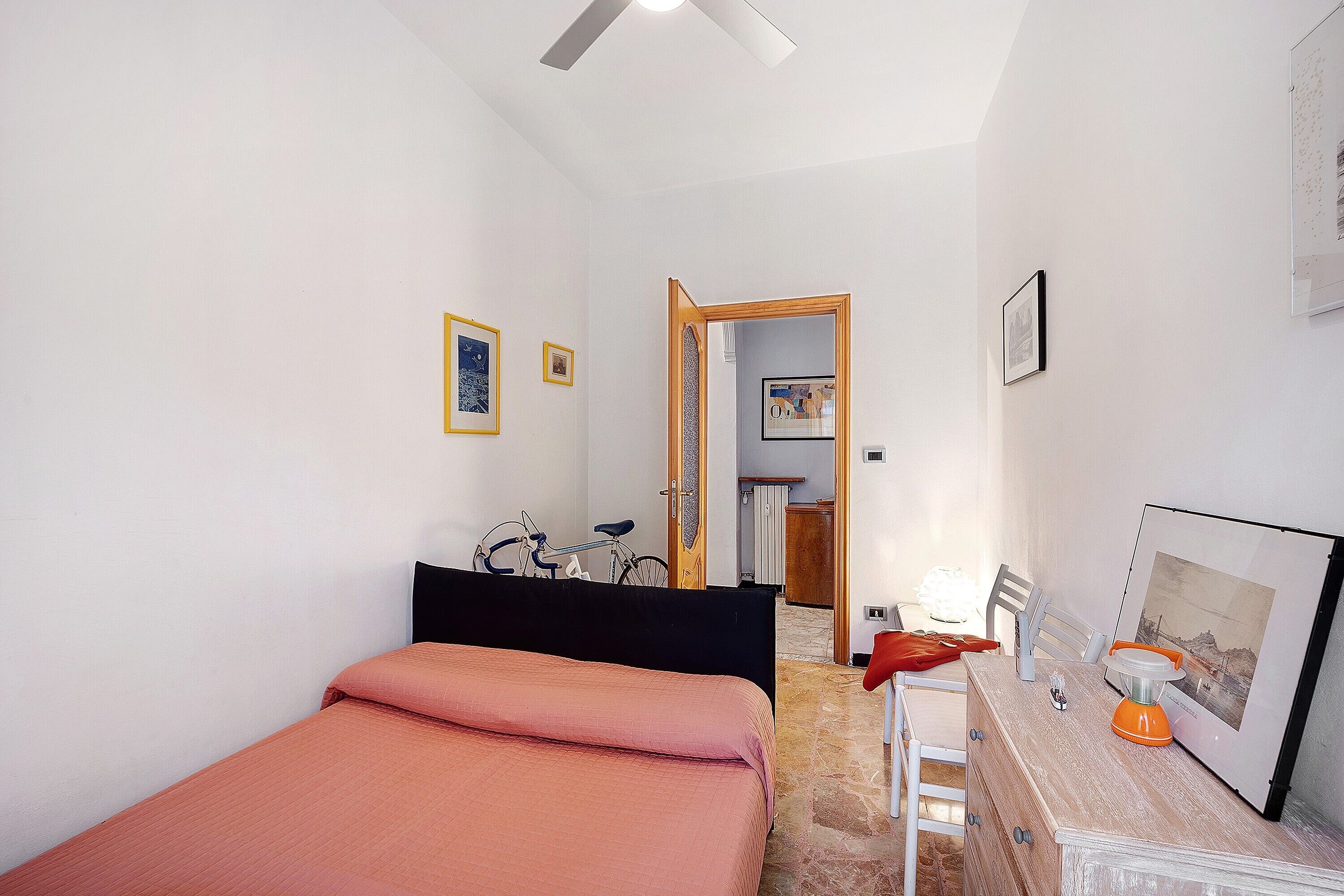 Un dormitorio con cama, escritorio y bicicleta.