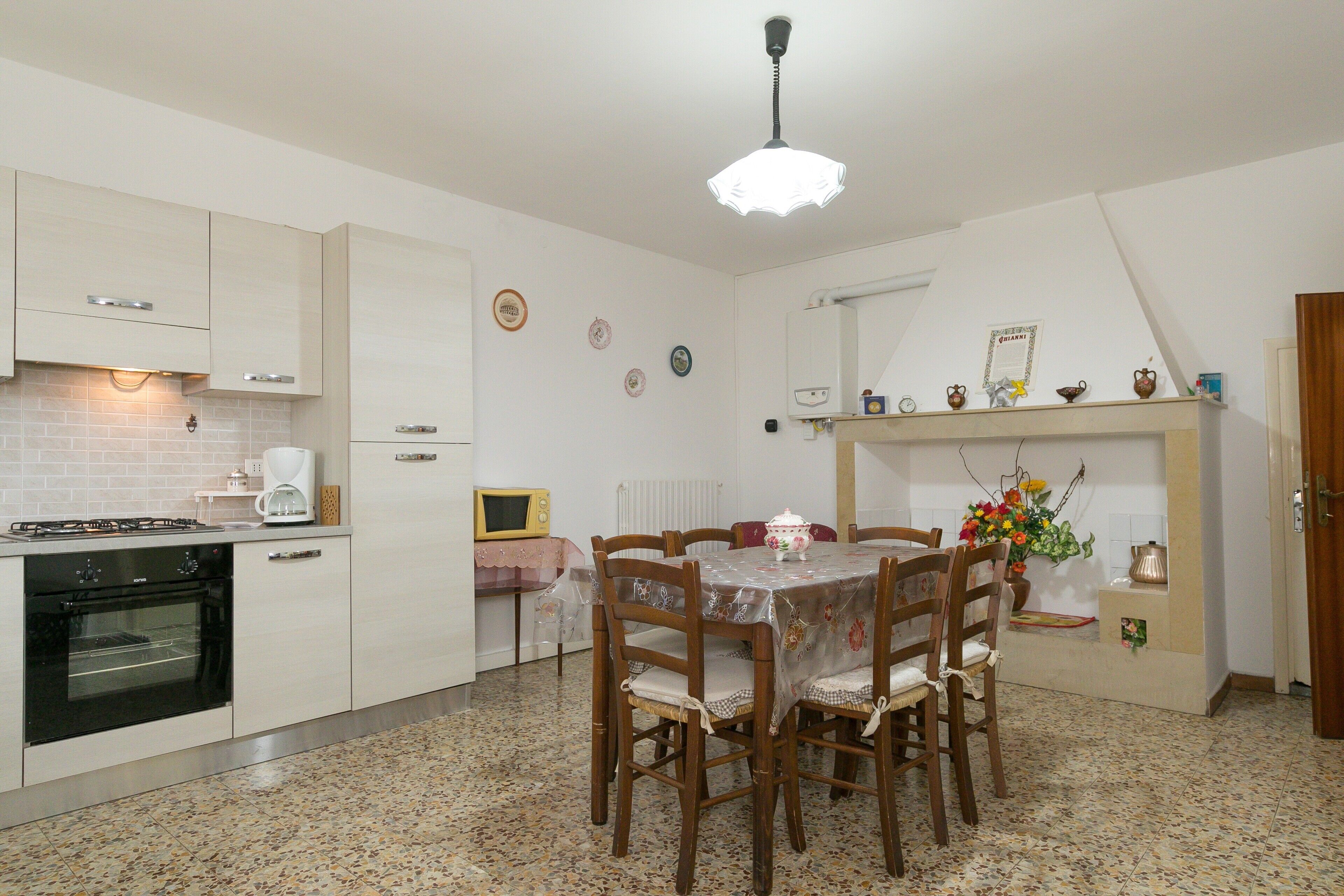 A kitchen with a dining table, chairs, a stove, and a microwave.