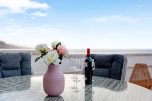 Ein Tisch mit einer Blumenvase, einer Weinflasche und Weingläsern.