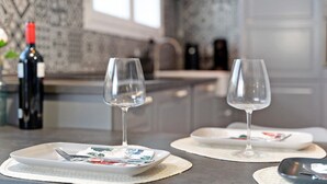 A dining table with two wine glasses, a bottle of wine, and a plate with cutlery. - Apartment "Casa Hola Mar" Directly on the Coast with Infinity Sea View (Los Realejos)