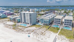 A coastal hotel with multiple buildings, a swimming pool, and a beach area. - Shoreline Towers (Gulf Shores)