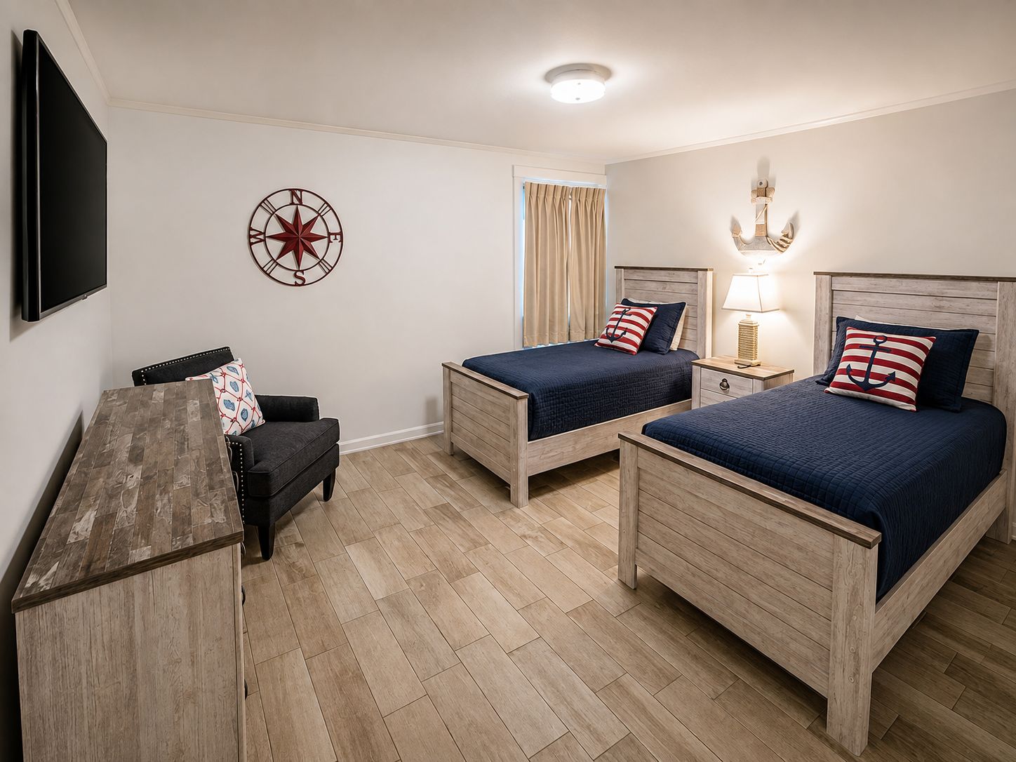 Une chambre d’hôtel avec deux lits en bois, un bureau, une chaise, une télévision et une décoration murale représentant une boussole.