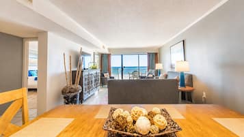 Une chambre d’hôtel comprenant un coin repas, un balcon avec vue et un comptoir de réception.