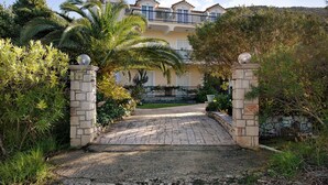Un bâtiment doté d’une entrée en pierre, d’un chemin pavé et d’un balcon.