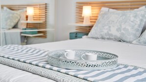 A neatly made bed with a striped blanket, a decorative tray with cups, and bedside lamps. - Holiday Home "Casa Sueña" Near the Beach with 4 Private Terraces (Calahonda  (Granada))