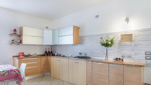 Une cuisine moderne avec des meubles en bois, un plan de travail et un coin repas comprenant une table et une chaise.