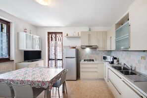 Une cuisine compacte comprenant une table à manger, des chaises, un réfrigérateur, une cuisinière et un four à micro-ondes.