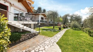 Un edificio residencial de varios pisos con un sendero de piedra que conduce a una zona verde.