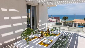Una terrazza con un tavolo apparecchiato per mangiare, vista mare.