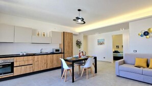 Un appartamento moderno con cucina, zona pranzo e soggiorno.