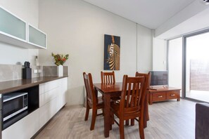 A modern kitchen with a dining area, a flat-screen TV, and a large window. - Waverley apartment B-one bedroom, wifi available (Perth)