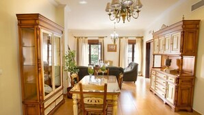 A dining area with a wooden table, chairs, and a chandelier. - Holiday Home "Casa Montelucía" with Mountain View, Terrace & Wi-Fi (Montecorto)