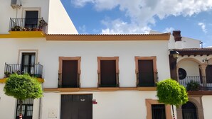 A two-story building with a balcony, a large door, and a small window. - Holiday Home "Casa Montelucía" with Mountain View, Terrace & Wi-Fi (Montecorto)