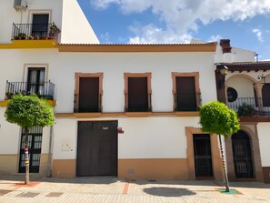 Un bâtiment à deux étages doté d’un balcon, d’une grande porte et d’une petite fenêtre.