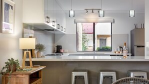 A modern kitchen with a large window, white countertops, and stainless steel appliances. - CONVENIENTLY LOCATED 250M (APPROX) TO THE EXQUISITE SHORES OF GEOGRAPHE BAY (Dunsborough)
