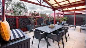 An outdoor patio with a covered seating area, a table, and chairs. - CONVENIENTLY LOCATED 250M (APPROX) TO THE EXQUISITE SHORES OF GEOGRAPHE BAY (Dunsborough)