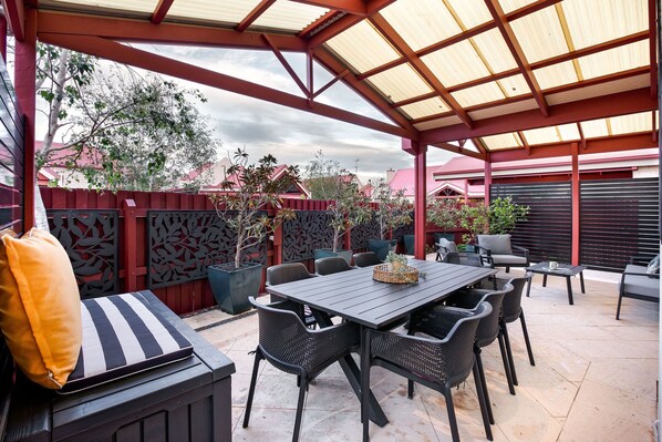 An outdoor patio with a covered seating area, a table, and chairs. - CONVENIENTLY LOCATED 250M (APPROX) TO THE EXQUISITE SHORES OF GEOGRAPHE BAY (Dunsborough)