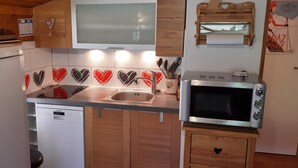 Una cocina compacta equipada con lavavajillas, microondas y pileta.