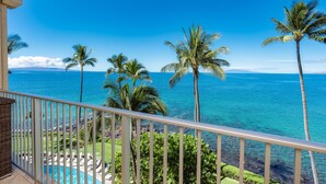 A balcony with a view of the ocean and palm trees. - TOP FLOOR-STUNNING OCEAN VIEWS-WELL EQUIPPED-ALL NEW FURNISHINGS (Kihei)