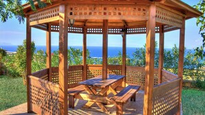 Un belvédère en bois, doté d’une table et de bancs, offrant une vue panoramique.