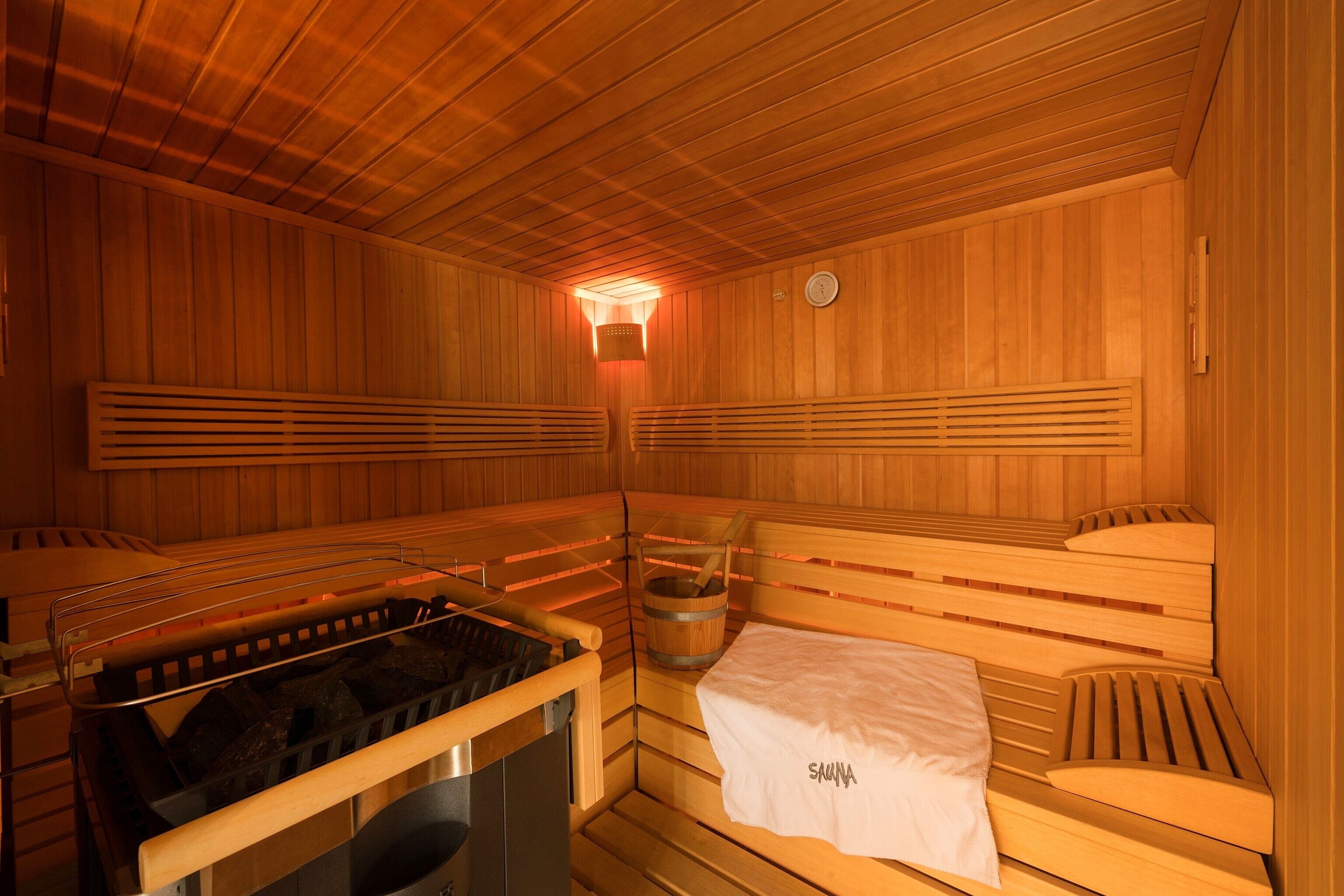 Una sauna con bancos de madera y un calentador para bancos.