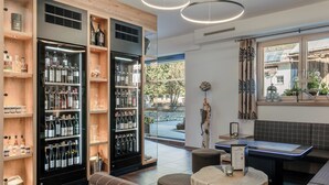 Zona de bar moderna con una selección de vinos y licores, asientos y vistas al área exterior.