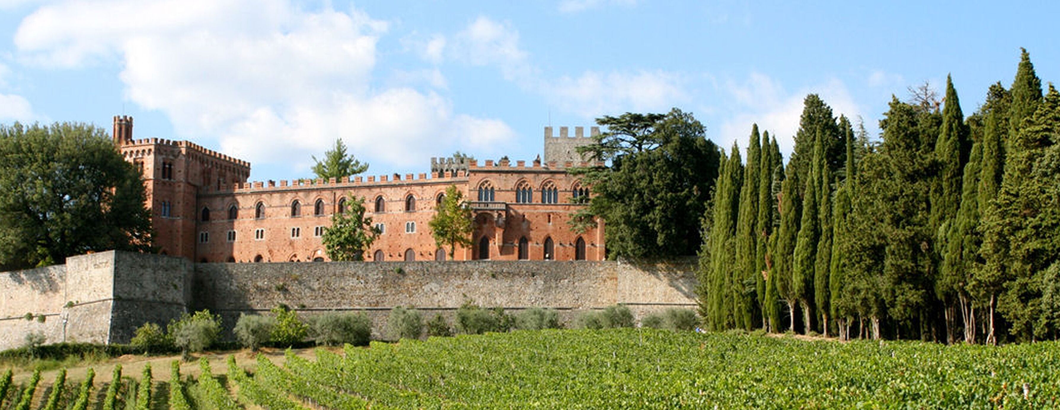 A historic building with a fortified wall, arched windows, and a tower.