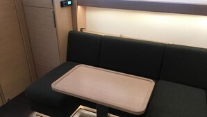 Uma área de estar compacta com uma pequena mesa, um painel de controle e uma luminária.