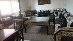 Un salon comprenant un ensemble de canapés, une table basse et un élément décoratif mural.