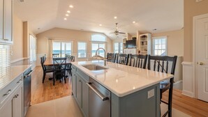 Un'ampia cucina con una grande isola, un'area pranzo con vista e una ventola a soffitto.