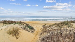 Una spiaggia con dune di sabbia e vista sull'oceano.