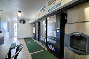 Un pasillo con máquinas expendedoras, un área de descanso y un refrigerador marca Scotsman.
