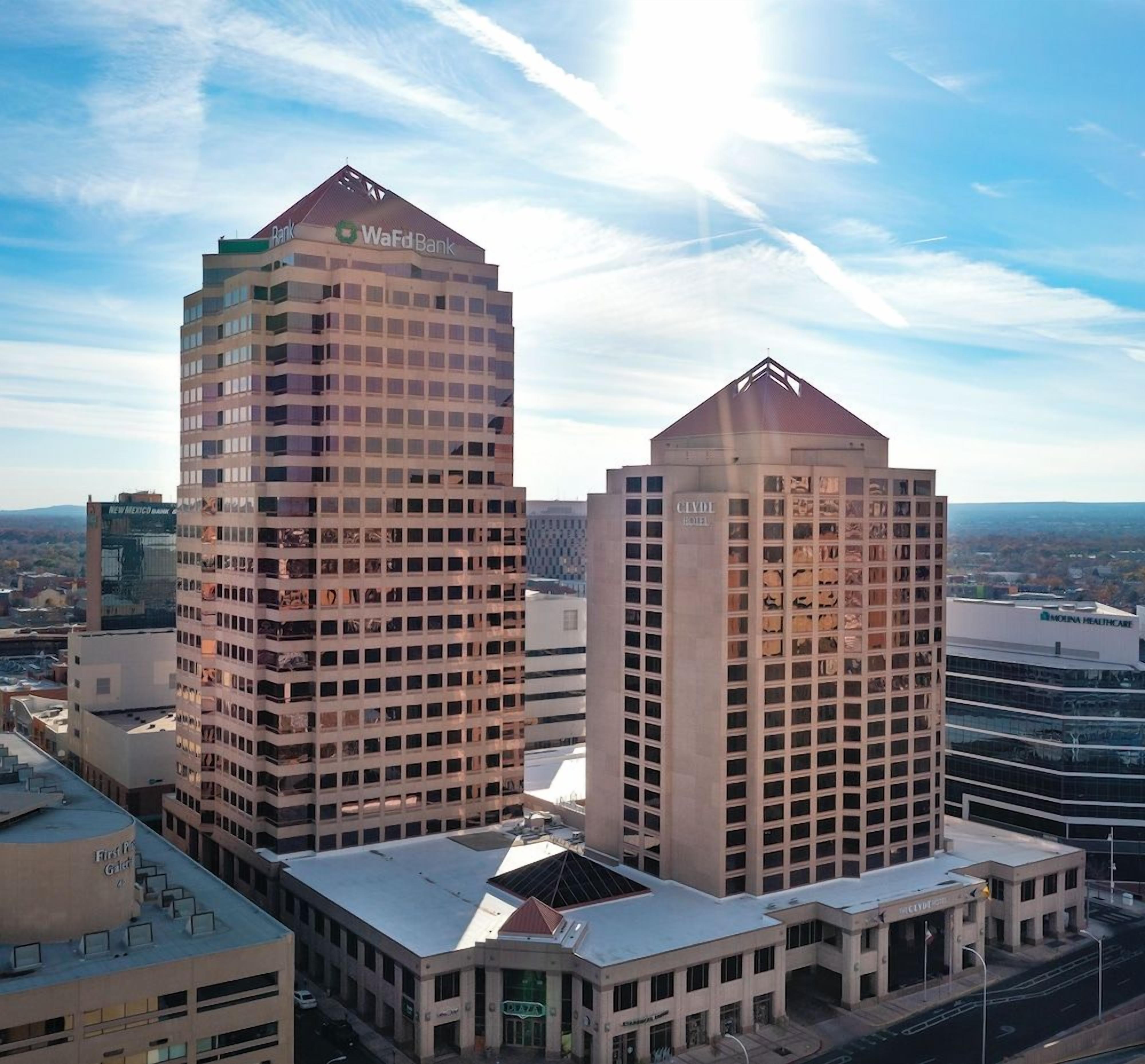 A high-rise building with multiple floors, a prominent bank sign, and a hotel adjacent to it.