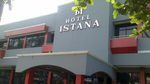 Un hôtel appelé « Hotel Istana », doté d’une façade moderne, de touches de couleur rouge et de grandes fenêtres.